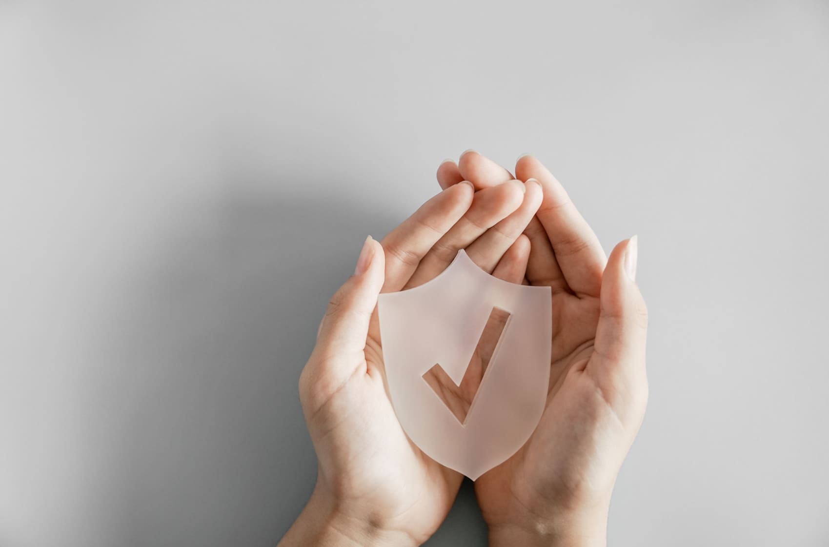 hands holding shield with checkmark