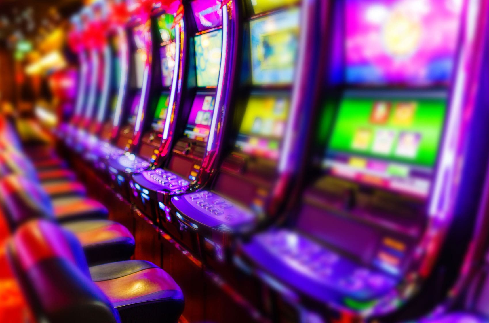 row-of-lit-slot-machines-in-a-casino
